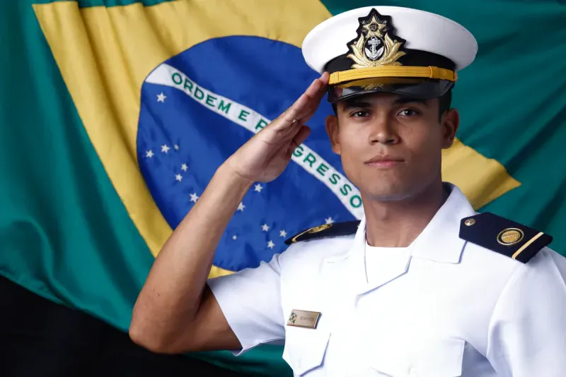 Matheus Renovato, de uniforme branco do Corpo de Engenheiros da Marinha, prestando continência